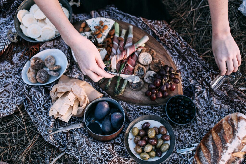 Camping food setup outdoors on a wooden table at a campsite